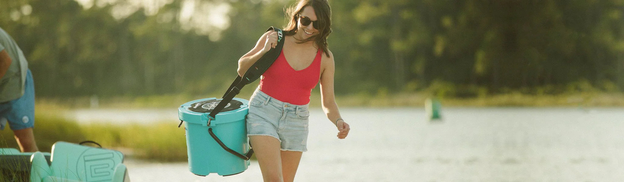 LAdy wearing Bote Kula Cooler on shoulder at the beach