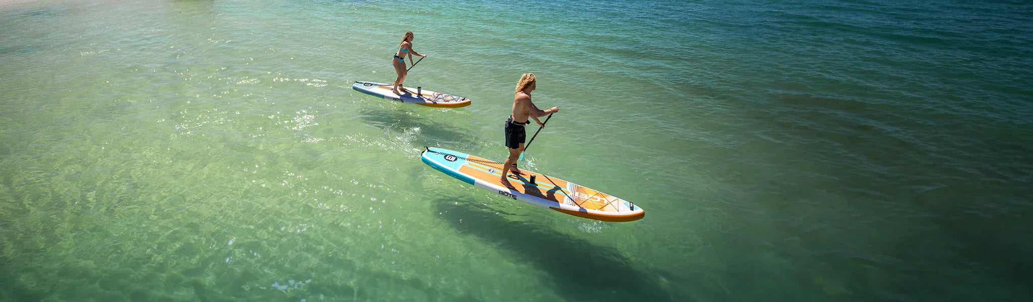 Two people paddling on BOTE paddle boards