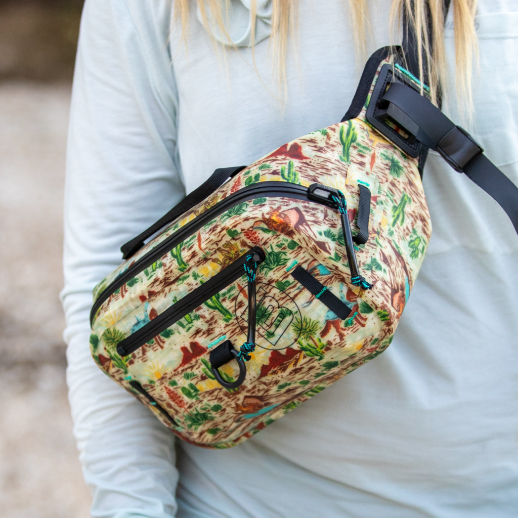Highwater Belt Pack Native Sendero worn crossbody, showing detailed desert scene print.