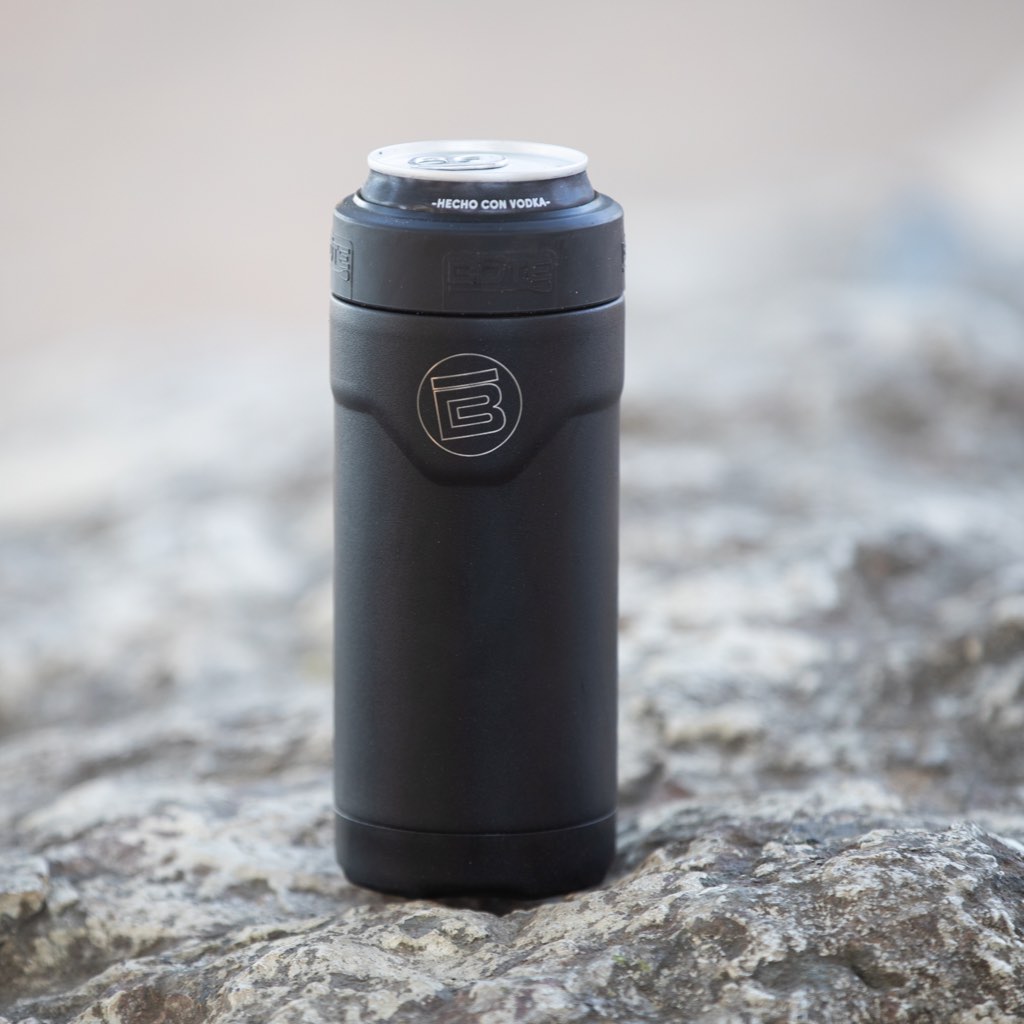 A MAGNEChill Can Cooler Slim with a drink in it while set on a rock