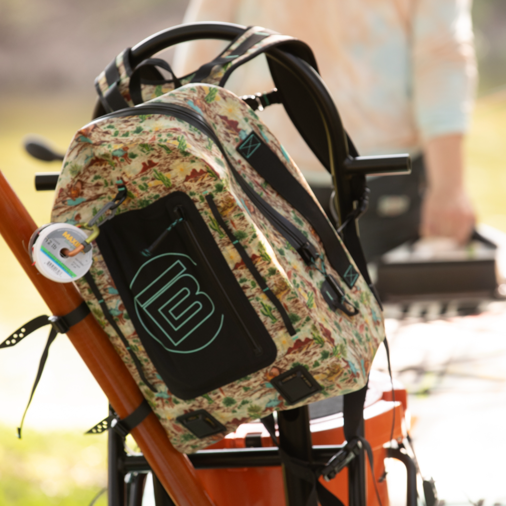 Highwater Backpack Native Sendero clipped to paddle gear, showing colorful desert pattern.
