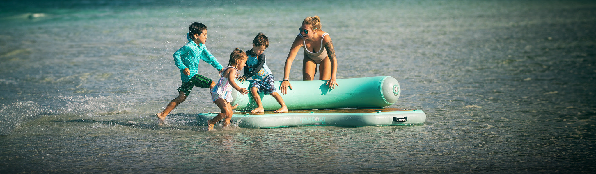 Children playing on an inflatable raft in shallow water