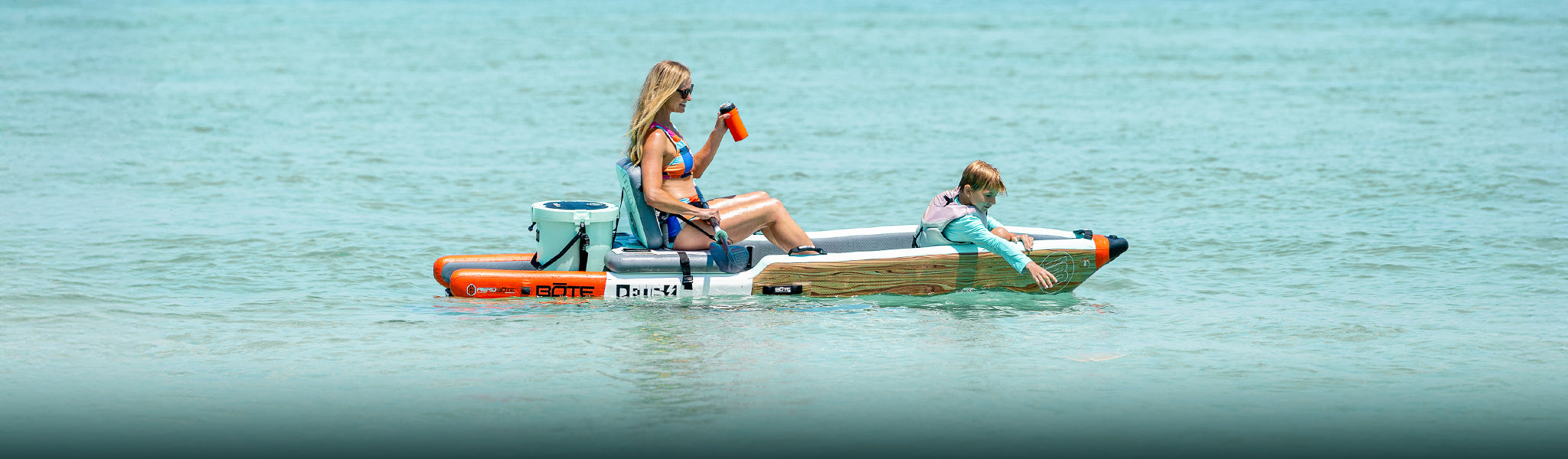 A woman sitting in an inflatable kayak with kid