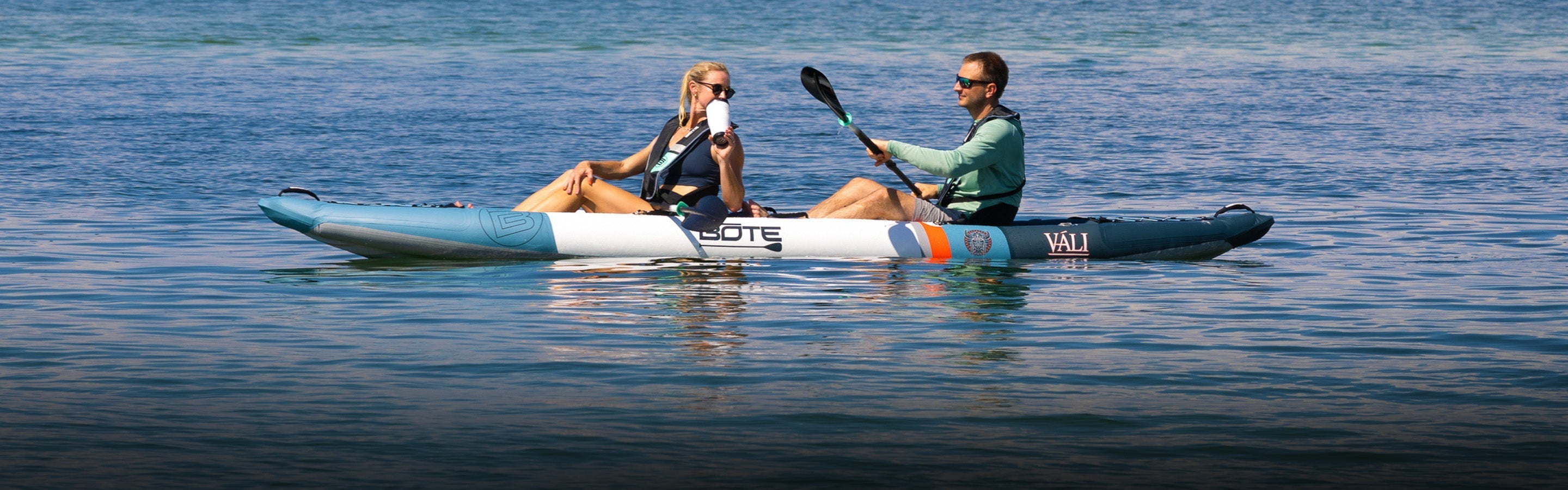Two people in a tandem kayak on calm water