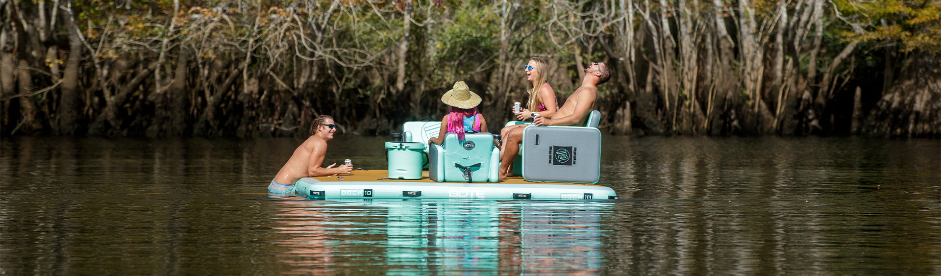 People enjoying a day on inflatable rafts in a natural setting with trees and water.