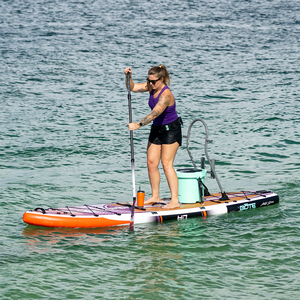 Woman paddleboarding on HD Aero Artist Series with cooler seat attached.