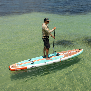 Man paddleboarding on HD Aero in shallow clear water with cup holder attached.