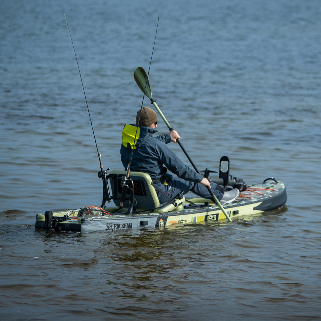 A guy sitting and paddling in a Rackham Aero 12′4″ Verge Camo Inflatable Paddle Board