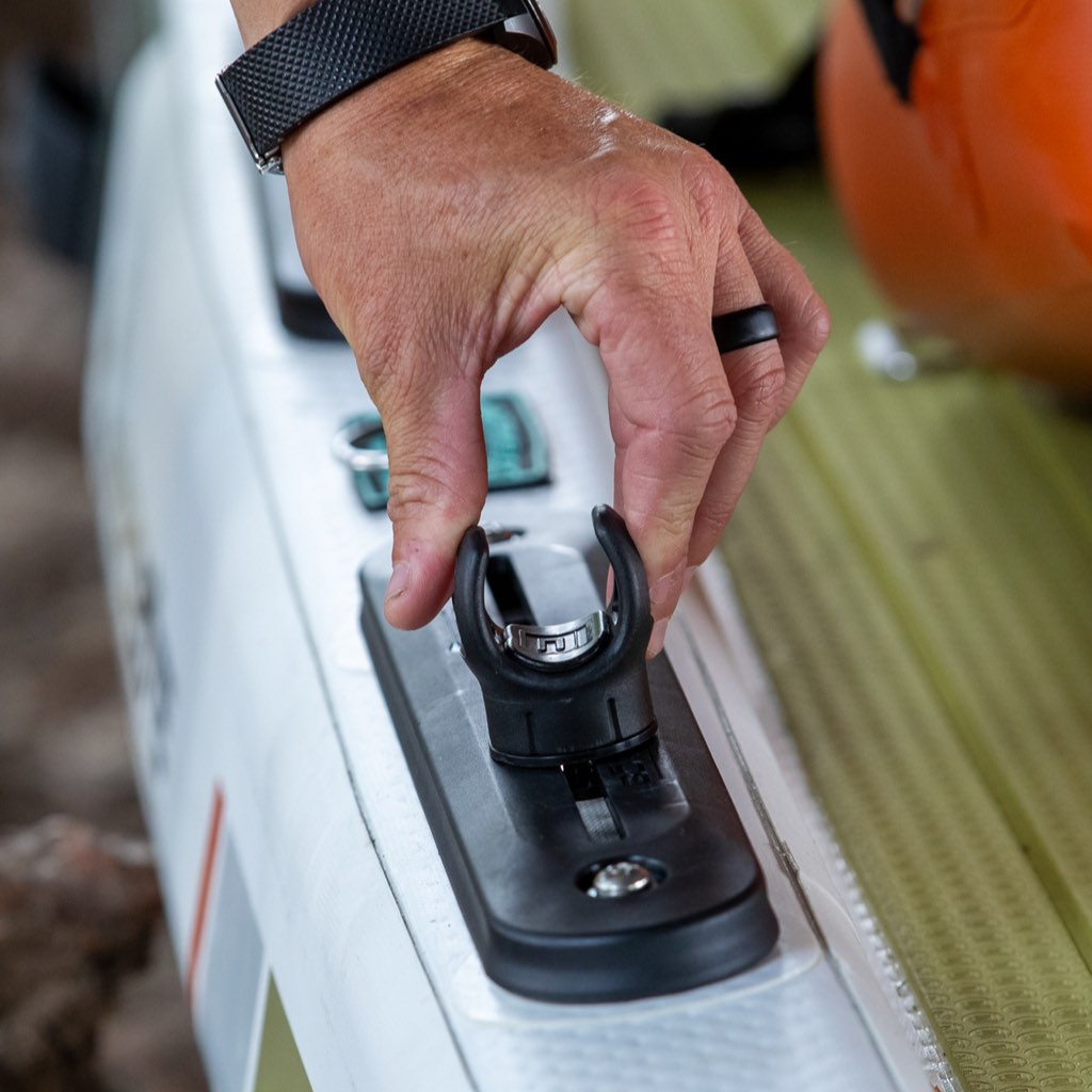 Hand placing Rail Rac Paddle Holder onto board-mounted rail system.