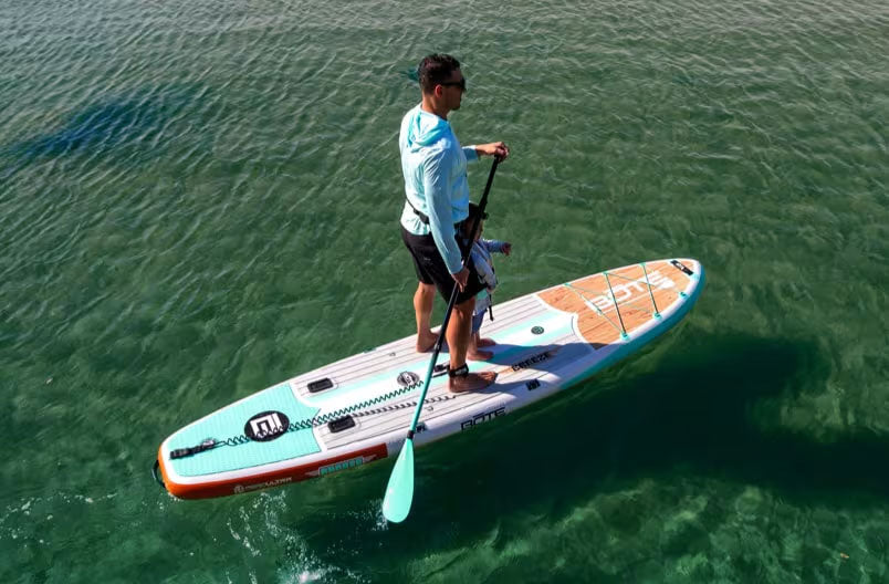 Person paddleboarding on a clear body of water