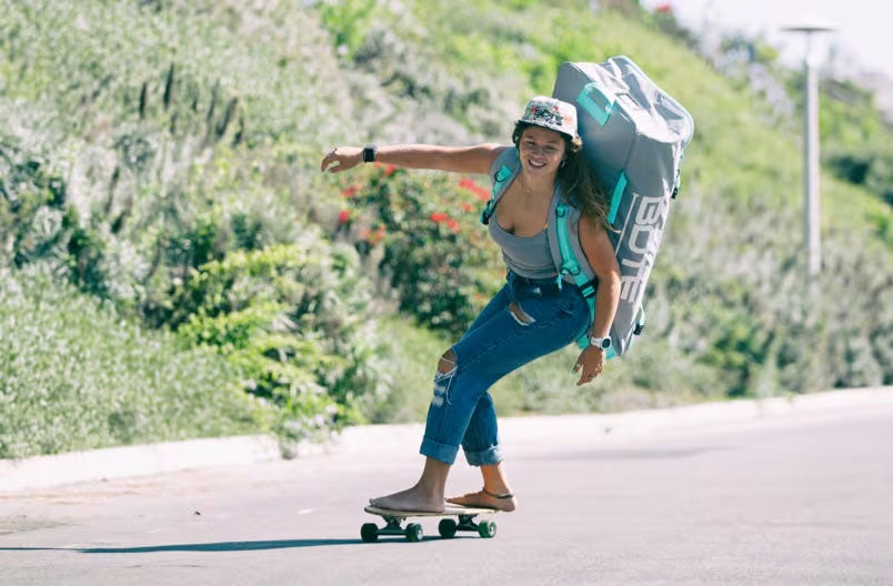 Person skateboarding with a backpack on a sunny day